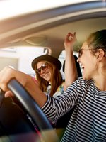 VRK Zusatzschutz – Junge Frau sitzt mit ihrer Freundin in Ihrem Auto.